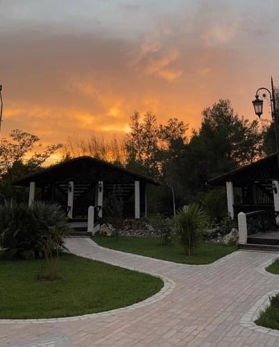 a house with a sunset in the background at Agroturizem Eldi in Fier