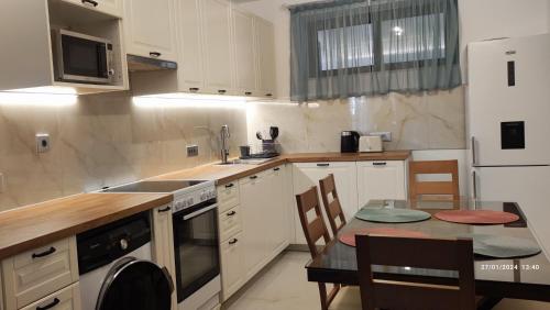 una cocina con armarios blancos y una mesa con comedor. en Villa Marina ixia, Rodos, en Ixia