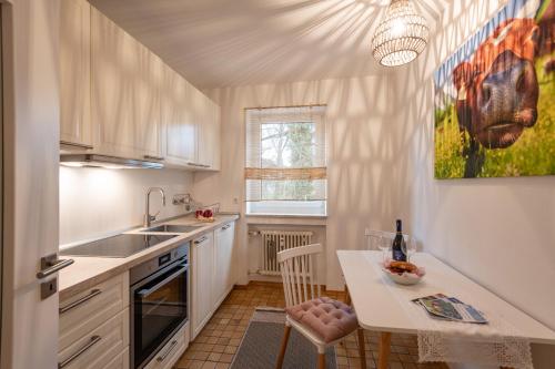una cucina con tavolo, lavandino e bancone di Ferienwohnung Brünnstein - Alpenmagie Suites a Oberaudorf