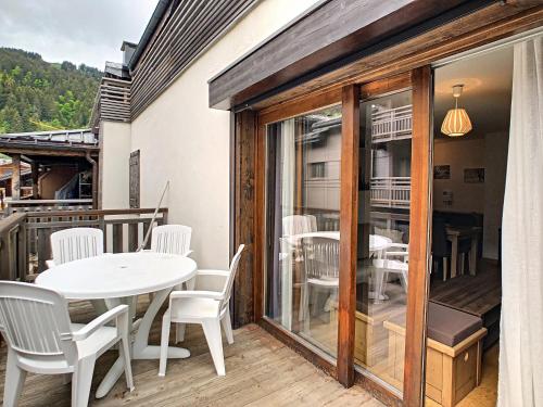 un patio avec une table et des chaises sur un balcon dans l'établissement Le Schuss - appartement - 4 pers - centre ville, aux Gets