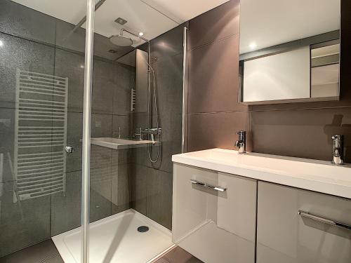 a bathroom with a shower and a sink and a mirror at Mont Caly - appartement - 8 pers - centre in Les Gets