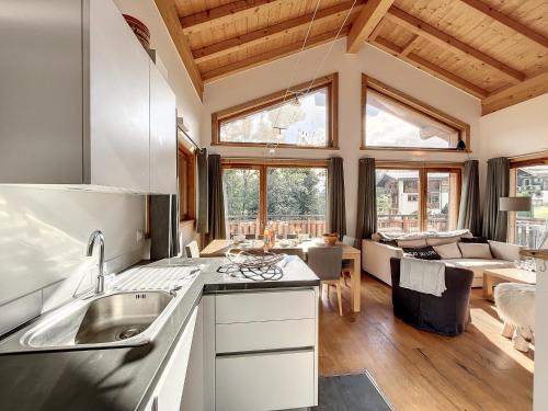 une cuisine avec un évier et un salon dans l'établissement Chalet Manasa - appartement- 8pers- proche piste, aux Gets