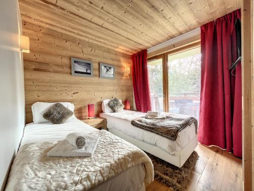 - une chambre avec 2 lits et une fenêtre avec des rideaux rouges dans l'établissement Chalet Manasa - appartement- 8pers- proche piste, aux Gets