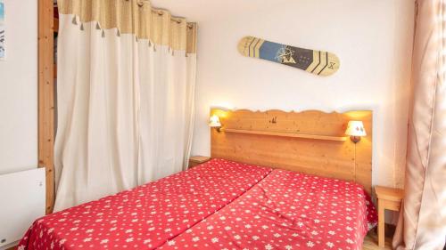 sypialnia z czerwonym łóżkiem i białą zasłoną w obiekcie ASTERS -A05- Studio lumineux 4-6 pers w mieście Chamrousse