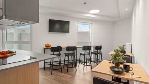 a kitchen with a counter and stools in a room at smartments Frankfurt City-Ost in Frankfurt/Main