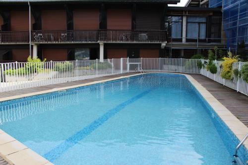 une grande piscine devant un immeuble dans l'établissement Grizzli 23 - appartement - 4 pers - Ski-in-out, aux Gets