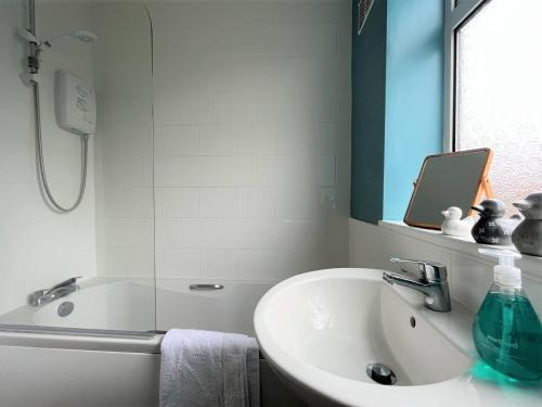 a bathroom with a sink and a bath tub with a mirror at Charming 3-bed Home In Bourne in Lincolnshire