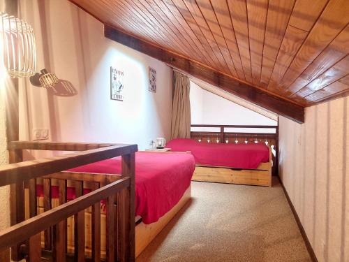 a bedroom with two beds with red sheets and a balcony at Cornuts 2 - appartement -5pers in Les Gets