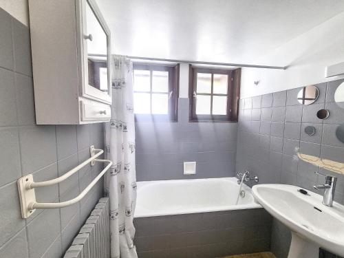 une salle de bain blanche avec une baignoire et un lavabo dans l'établissement Cornuts 2 - appartement -5pers, aux Gets