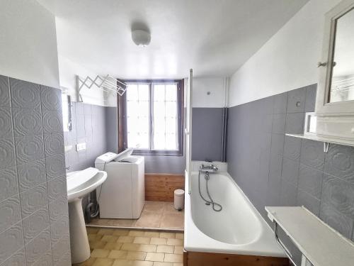 une salle de bain blanche avec une baignoire et un lavabo dans l'établissement Cornuts 3 - appartement - 7pers, aux Gets