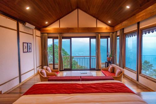 a bedroom with a large bed and large windows at Eagle's Nest in Bhurtuk