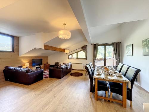 - un salon avec une table et des fauteuils en cuir dans l'établissement Bois de Chene - appartement - 6pers- proche centre, aux Gets