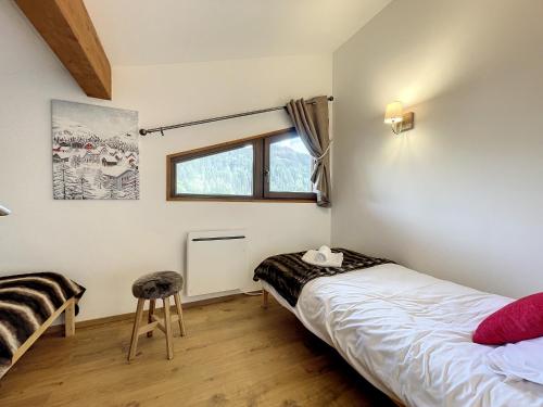 - une chambre avec 2 lits et un tabouret dans l'établissement Bois de Chene - appartement - 6pers- proche centre, aux Gets