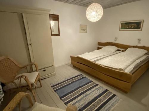 a bedroom with a bed and a chair and a rug at Sandpärlan 8 - Havet Österlen in Simrishamn
