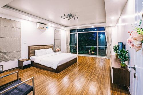 - une chambre avec un lit et une grande fenêtre dans l'établissement Villa FLC Sầm Sơn - Sao biển 98, à Sầm Sơn