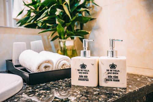 two bottles of soap and towels on a counter in a bathroom at Villa FLC Sầm Sơn - Sao biển 98 in Sầm Sơn