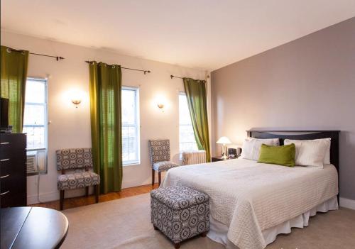 una camera da letto con un grande letto con tende verdi di Gorgeous Apt for 2! Heart of Manhattan! a New York