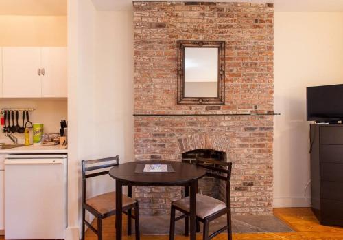a brick fireplace with a table and a mirror at Gorgeous Apt for 2! Heart of Manhattan! in New York