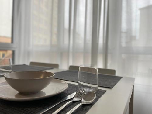 a table with a bowl and a plate and fork at Cies Suitel López de Neira 28 - Love your Stay in Vigo