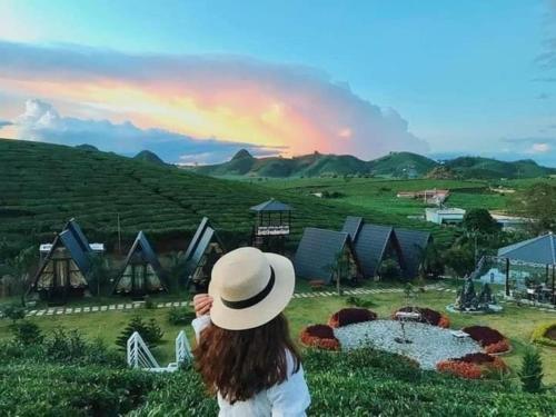 a woman wearing a hat looking at a farm at Thung Lũng Ba Đồi Chè in Mộc Châu