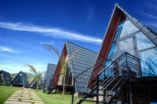 a house with glass windows on the side of it at Thung Lũng Ba Đồi Chè in Mộc Châu