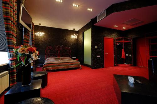 トムスクにあるHotel Toyanの赤いカーペットフロアのベッドルーム1室(ベッド1台付)