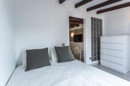a white bed with two pillows in a bedroom at Apartamento La boqueria Atic in Barcelona