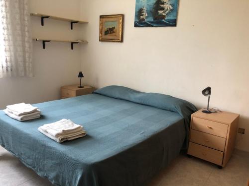 1 dormitorio con 1 cama azul y 2 toallas en Casa Maris en Torre Grande