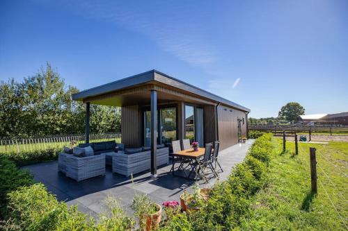 a small cabin with a table and chairs in a garden at Sunset Lodge in Lutten