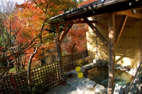 a wooden gazebo with a pool of water at Sawatari Onsen Miyataya Ryokan in Nakanojo
