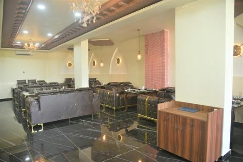 a conference room with leather chairs and a chandelier at Hotel Jurkis, Kolhapur in Kolhapur