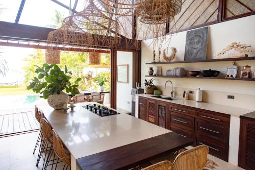 a kitchen with a large kitchen island with a table at Mantaray Siargao in General Luna