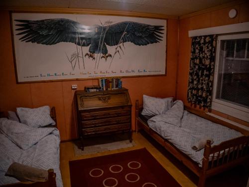 een slaapkamer met 2 bedden en een foto van vogels bij Hostel Majatalo Hetekka in Kouvola