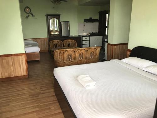 a bedroom with a bed and two wicker chairs at Hotel Mandala in Kathmandu