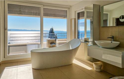 ein Badezimmer mit Badewanne und Waschbecken und einem Fenster in der Unterkunft Apartment Oliva allegra in Split