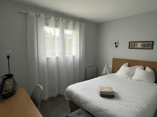 ein Schlafzimmer mit einem Bett und einem Fenster mit einem Buch darauf in der Unterkunft le toul braz in Saint-Gildas-de-Rhuys