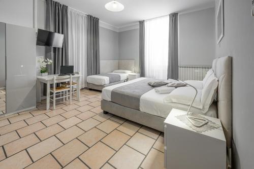 トリエステにあるAffittacamere Berziのベッド2台とデスクが備わるホテルルームです。