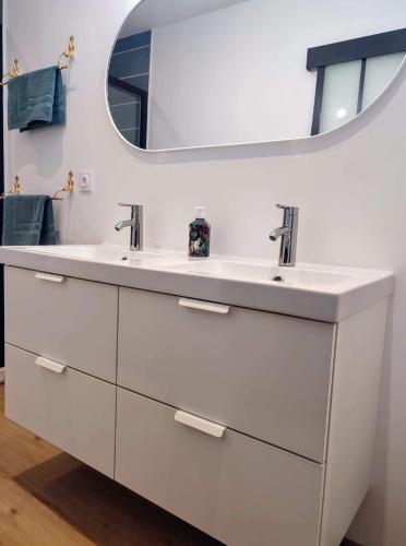 une salle de bain blanche avec deux lavabos et un miroir dans l'établissement Centre bourg, spacieux duplex classé 3 étoiles, Plages à 5 min, à Plouguerneau