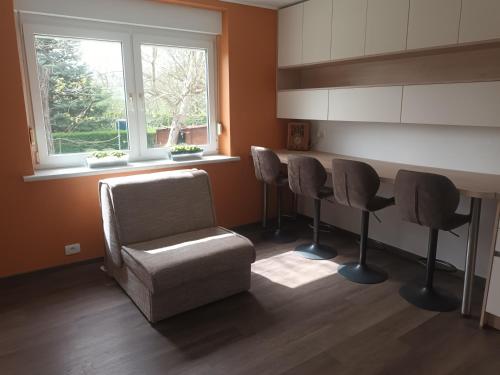 sala de estar con mesa, sillas y silla en The Cottage en Murska Sobota