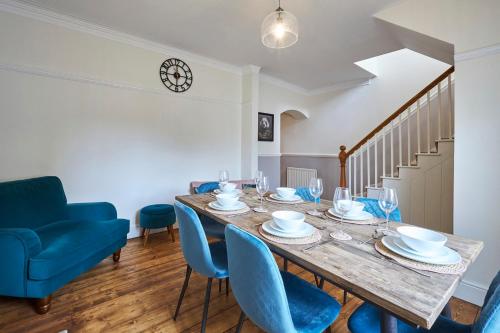 a dining room with a wooden table and blue chairs at Host & Stay - Oliver's Den in Alnwick