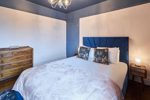 a bedroom with a large bed with a blue headboard at Host & Stay - Oliver's Den in Alnwick