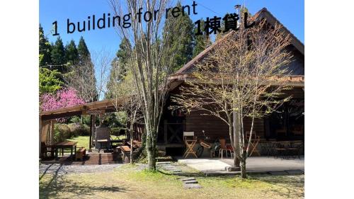 a building for rent with trees in front of it at Guesthouse Coco Garage in Kirishima