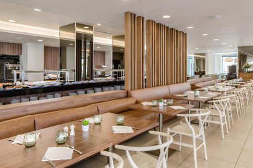 a restaurant with tables and chairs and a bar at NAU Sao Rafael Suites - All Inclusive in Albufeira