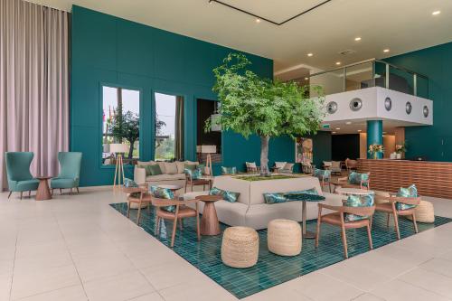 eine Lobby mit blauen Wänden, Tischen und Stühlen in der Unterkunft NAU Sao Rafael Suites - All Inclusive in Albufeira