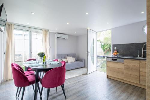 a kitchen and dining room with a table and pink chairs at Maison sur L'eau in Cergy