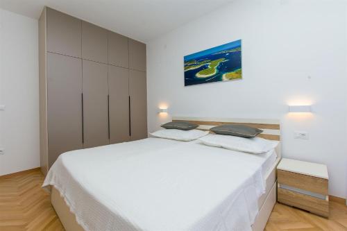 a white bedroom with a large white bed in it at Apartment Marija in Krilo