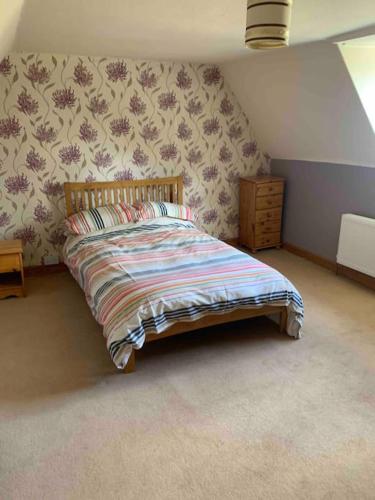 a bed in a bedroom with a wall at Gullers End Farm Cottage in Long Green