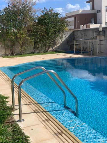 an empty swimming pool with a metal hand rail in a building at Events Hause in Gammarth