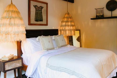 a bedroom with a white bed with two pillows at Mantaray Siargao in General Luna