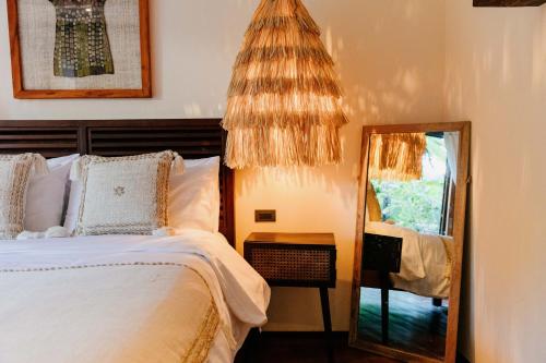 a bedroom with a bed and a mirror at Mantaray Siargao in General Luna